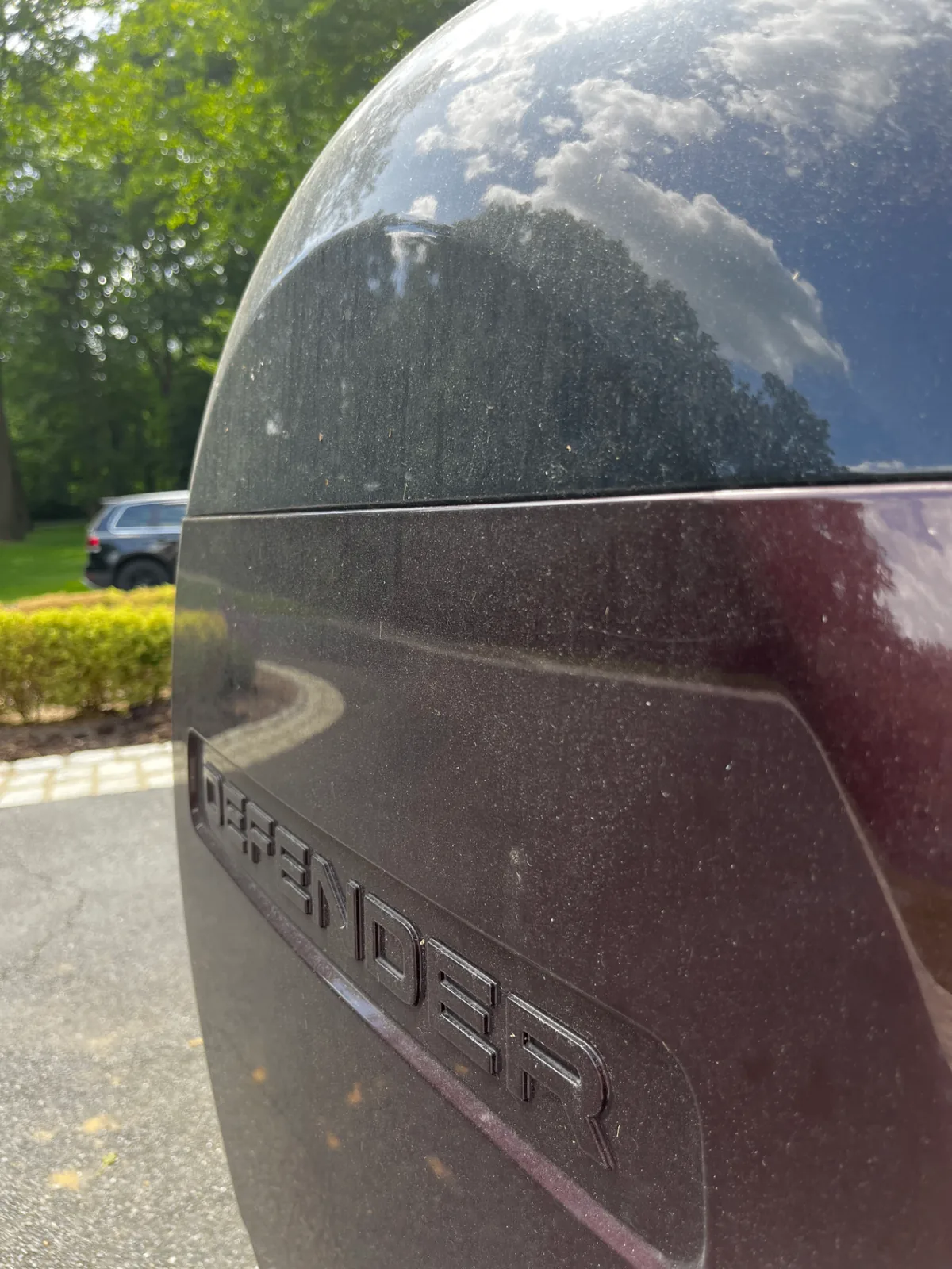 Dusty rear Defender badge on a dark SUV before Bluefin detailing