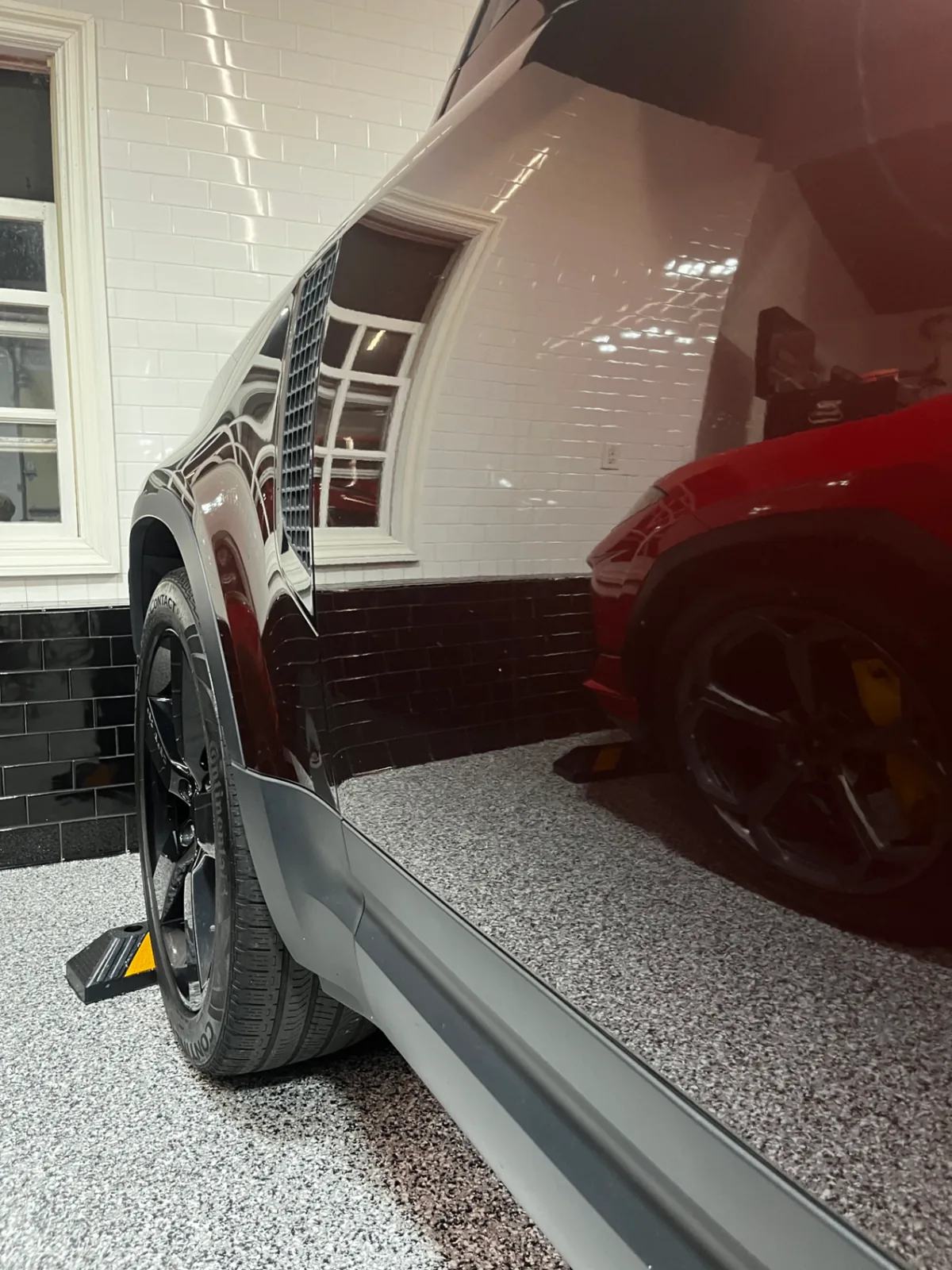 Same maroon SUV side panel polished to a mirror-like reflection after Bluefin detailing